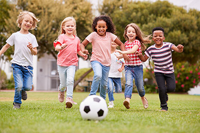 A group of children playing football in the park